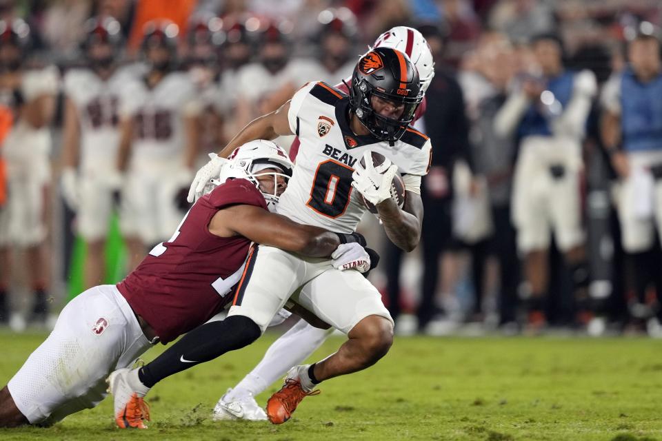 Oct 8, 2022; Stanford, California, USA; Oregon State Beavers wide receiver Tre'Shaun Harrison (0) is tackled by Stanford Cardinal linebacker Jacob Mangum-Farrar (14) after a catch during the second quarter at Stanford Stadium.