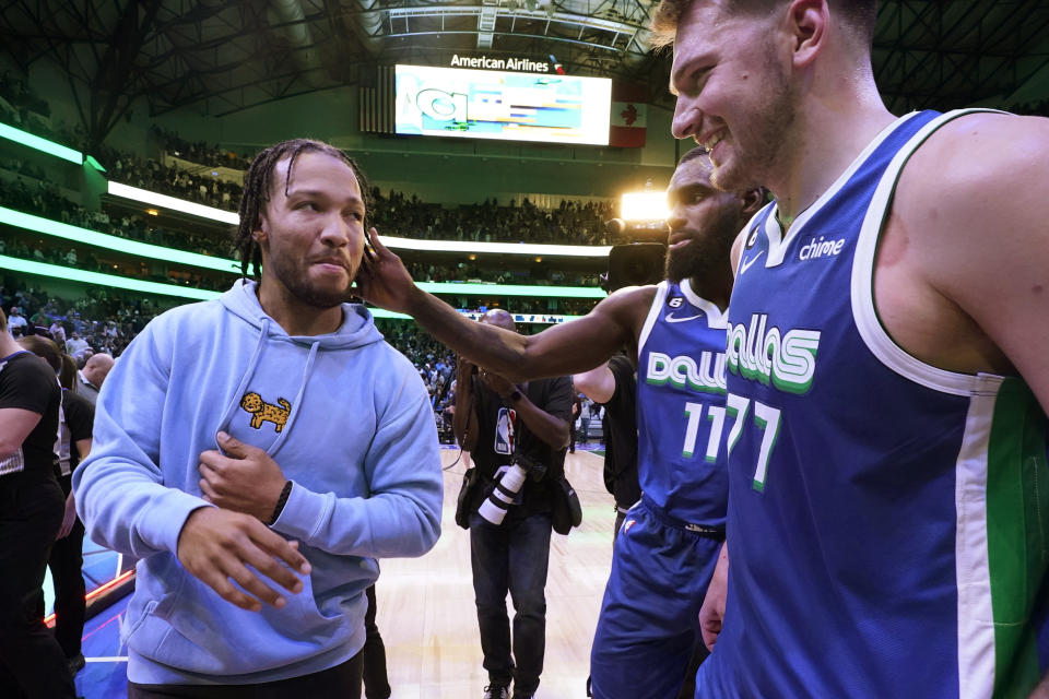 New York Knicks guard Jalen Brunson, left, is greeted by Dallas Mavericks forward Tim Hardaway Jr. (11) and guard Luka Doncic after an NBA basketball game in Dallas, Tuesday, Dec. 27, 2022. The Mavericks won in overtime, 126-121. (AP Photo/LM Otero)