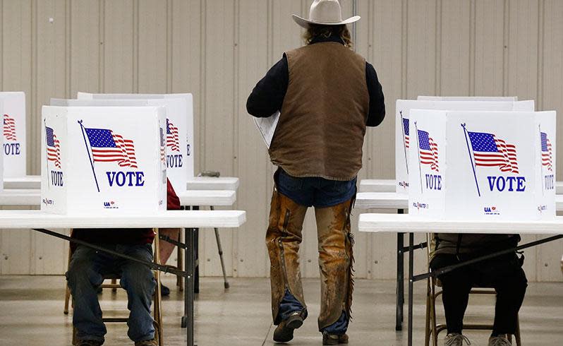 A voter dressed as a cowboy walks back to a table with his ballet to vote at a polling location in Kansas. Photo: AAP