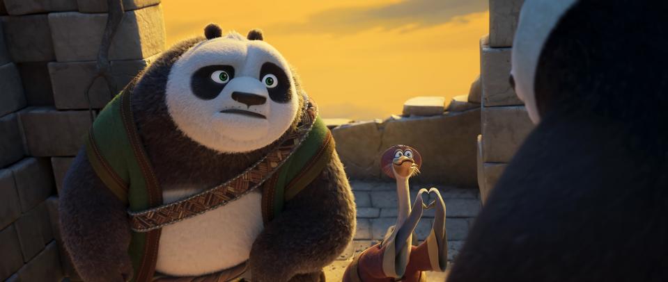 Po from Kung Fu Panda looks concerned while talking to Mr. Ping, who is using hand gestures, with another panda in the foreground