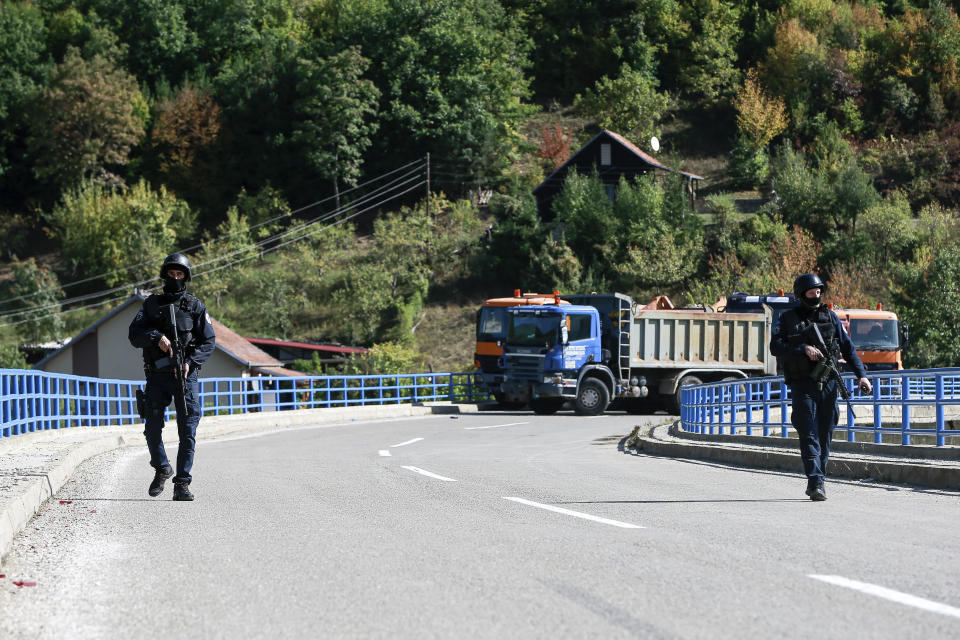 Kosovo police officers patrol the bridge over Gazivode lake near the northern Kosovo border crossing of Brnjak on the fifth day of protest on Friday, Sept. 24, 2021. Ethnic Serbs in Kosovo have been blocking the border for a fifth straight day to protest a decision by Kosovo authorities to start removing Serbian license plates from cars entering the country, raising fears such incidents could unleash much deeper tensions between the two Balkan foes.(AP Photo/Visar Kryeziu)