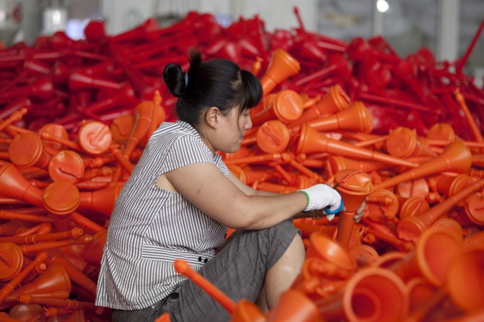 A worker produces plastic horns, also called vuvuzelas, at a factory in Ningbo, Zhejiang Province, China, on Thursday, June 14, 2012. (Nelson Ching/Bloomberg)
