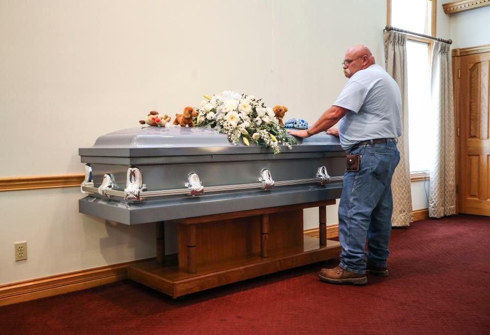 Jeffrey Meredith pauses over the casket of a boy whose body was found in a suitcase in Southern Indiana.