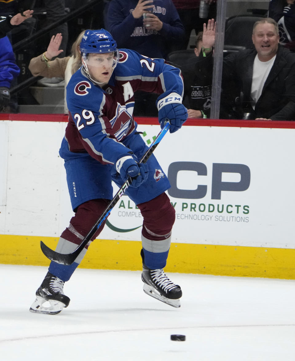 Colorado Avalanche center Nathan MacKinnon shoots for an empty-net goal, his fourth tally of the night, during the third period of the team's NHL hockey game against the Ottawa Senators on Thursday, Dec. 21, 2023, in Denver. (AP Photo/David Zalubowski)