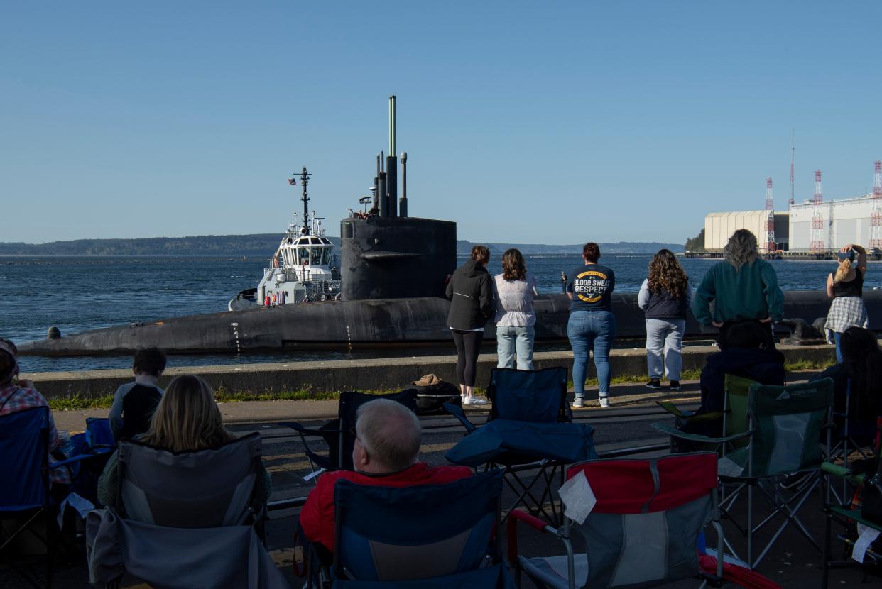 Families wait on the pier as the Ohio-class ballistic missile submarine USS Henry M. Jackson (SSBN-730) prepares to moor at Naval Base Kitsap–Bangor after completing a patrol on April 27, 2023. Henry M. Jackson is one of eight ballistic-missile submarines stationed at Naval Base Kitsap-Bangor.