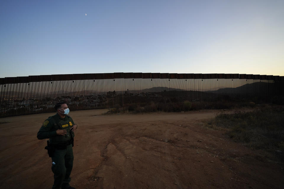 Border Patrol agent Justin Castrejon looks out along newly replaced border wall sections Thursday, Sept. 24, 2020, near Tecate, Calif. Top Trump administration officials will visit South Texas five days before Election Day to announce they have completed 400 miles of U.S.-Mexico border wall, attempting to show progress on perhaps the president's best-known campaign promise four years ago. But most of the wall went up in areas that already had smaller barriers. (AP Photo/Gregory Bull)