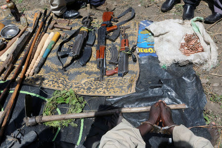 A royal guard to Charles Wesley Mumbere, king of the Rwenzururu kingdom, is seen handcuffed after Uganda security agencies apprehended him with assault rifles and improvised explosive devices during a search at one of the kingdom’s shrines near Kasese town, western Uganda bordering with Democratic Republic of Congo, November 29, 2016. REUTERS/James Akena