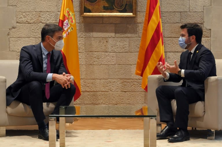 Pedro Sánchez (E) ouve Pere Aragonès durante uma reunião que mantiveram no Palácio da Generalitat, sede do governo regional, em 15 de setembro de 2021, em Barcelona (AFP/Lluís Gené)