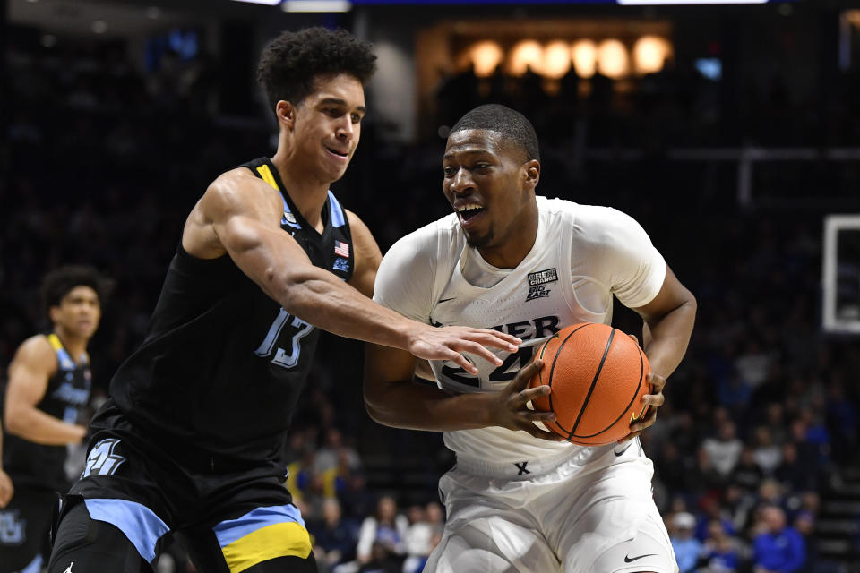 Marquette forward Oso Ighodaro (13) attempts to strip the ball away from Xavier forward Abou Ousmane (24) during the first half of an NCAA college basketball game in Cincinnati, Saturday, March 9, 2024. (AP Photo/Timothy D. Easley)