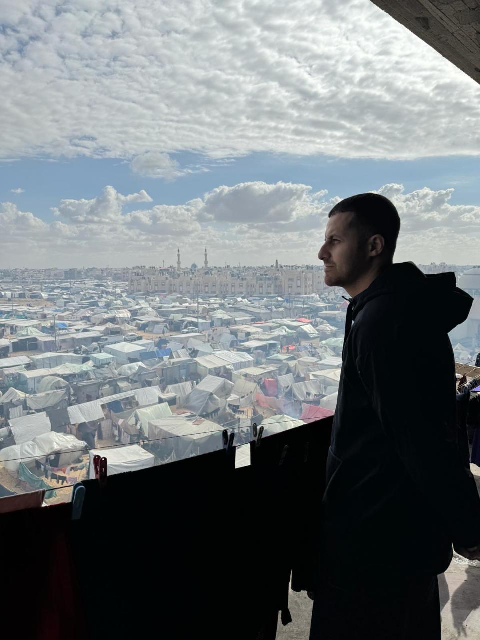 Dr. Thaer Ahmad, a Palestinian American emergency medicine specialist in Chicago volunteering in the southern Gaza Strip in January 2024, looks out over tents of displaced Palestinians in Rafah.