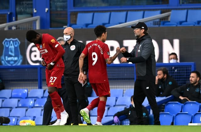 Liverpool manager Jurgen Klopp fistbumps Roberto Firmino as he is replaced by Divock Origi 