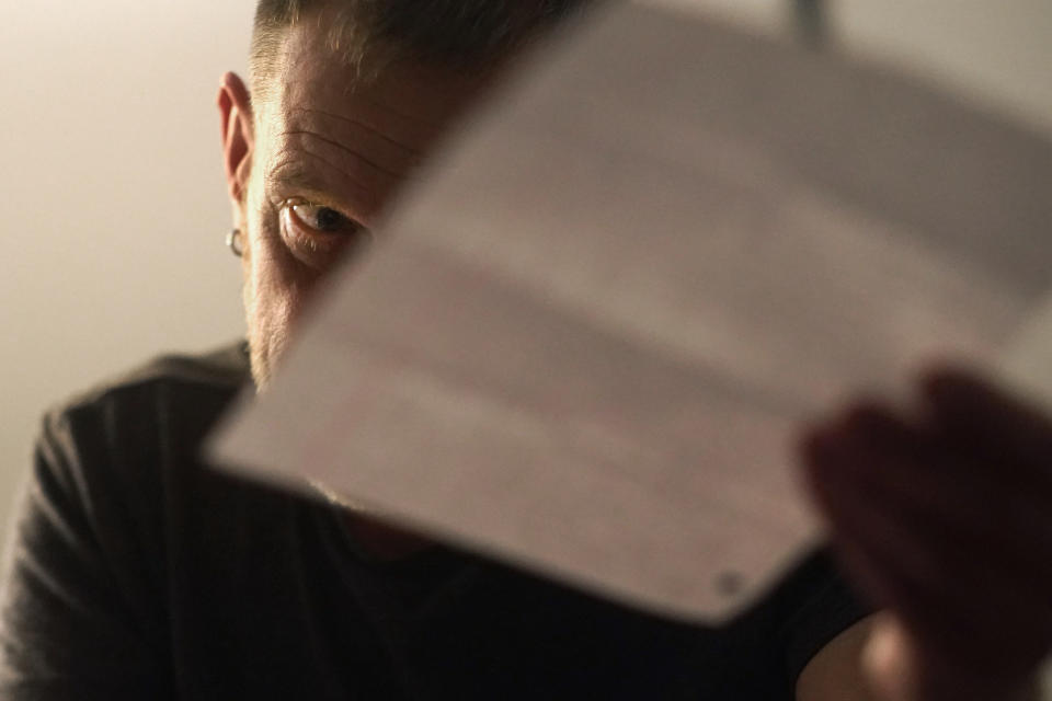 Brad Marler holds a letter from his daughter during an interview Monday, Oct. 4, 2021, in Chicago. Brad and his wife, Cyndi, say they never would have been able to come out if their parents were still alive. Cyndi's father was the last to die, in late 2019. But the final push came when their daughter came out as a lesbian. "It was the overwhelming need to protect her," said Brad, whose daughter recently wrote her parents each a letter saying what this has all meant to her. (AP Photo/Charles Rex Arbogast)