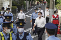 Police officers gather in front of the Poland's Embassy in Tokyo before a van with Belarusian Olympic sprinter Krystsina Tsimanouskaya leaves Wednesday, Aug. 4, 2021. Tsimanouskaya plans to seek refuge in Europe after accusing team officials of trying to force her to leave the Tokyo Games early. (AP Photo/Kantaro Komiya)