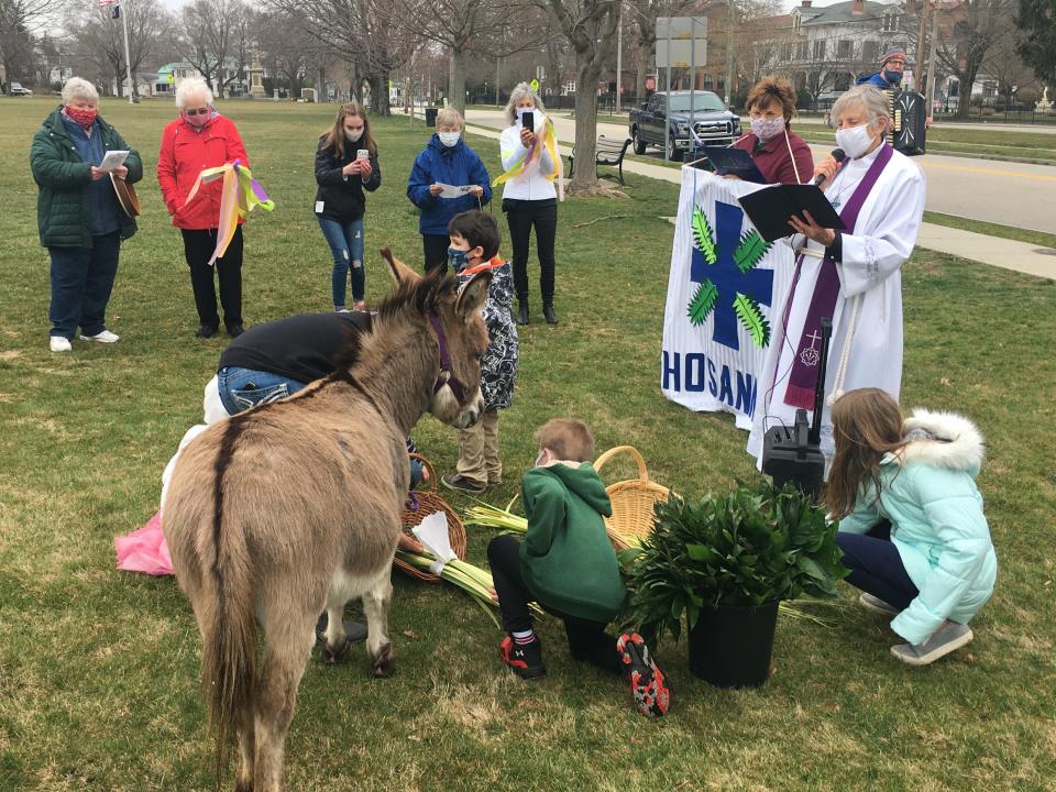 Rev. Mary Robinson (right) of St. Mark Evangelical Lutheran Church in Norwich reads a blessing of the psalms in this file photo, while children and Maybe the Donkey from the Sheffield Way Farm in Exeter, RI, help out.