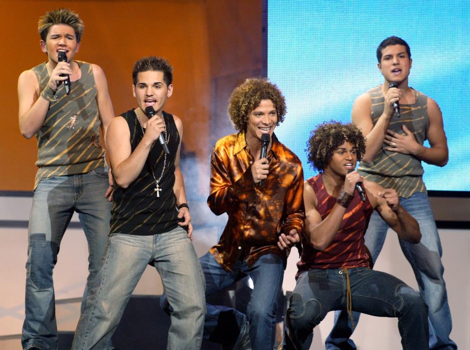 (L-R) "American Idol" finalists Jim Verraros, AJ Gil, Justin Guarini, EJ Day and RJ Helton perform during the "American Idol in Vegas" concert at the MGM Grand Garden Arena September 18, 2002 in Las Vegas, Nevada.  (Photo by Ethan Miller/Getty Images)