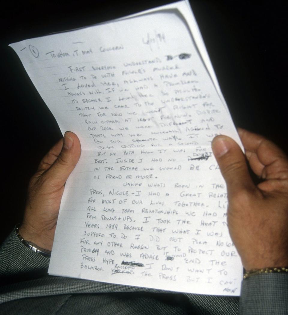 A page of a hand-written letter held by someone off camera.