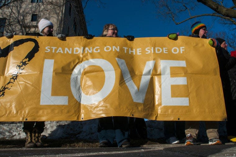 Supporters hold up a banner during a pro-gay marriage rally held by the Unitarian Universalist Church of Flint, Michigan outside of the Genesee County Courthouse in Flint, Mich.