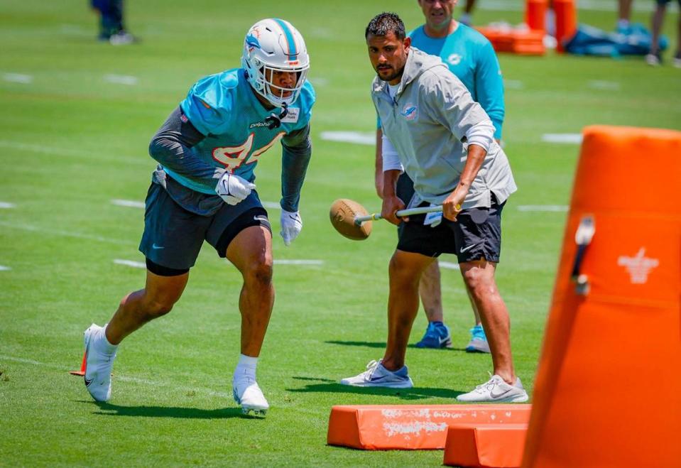 Miami Dolphins outside linebackers coach Ryan Crow works with linebacker Chop Robinson.