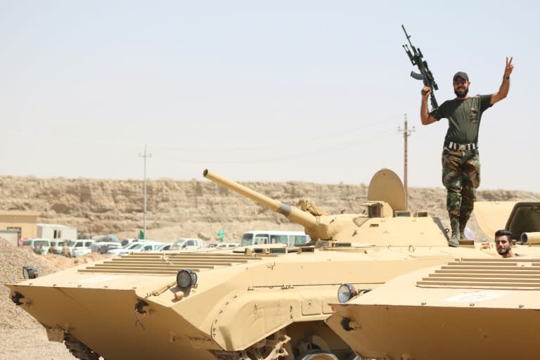 A fighter from the Popular Mobilisation units flashes the victory sign on top of a tank during a military operation against IS group jihadists on the road leading to Saqlawiya, in Iraq's Anbar province on August 19, 2015