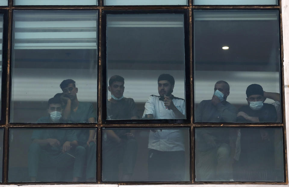 Hospital staff watch as the body of Saeb Erekat arrives to a hospital morgue, in the West Bank city of Ramallah, Tuesday, Nov. 10, 2020. Erekat, a veteran peace negotiator and prominent international spokesman for the Palestinians for more than three decades, died Tuesday, weeks after being hospitalized with the coronavirus. He was 65. (AP Photo/Nasser Nasser)