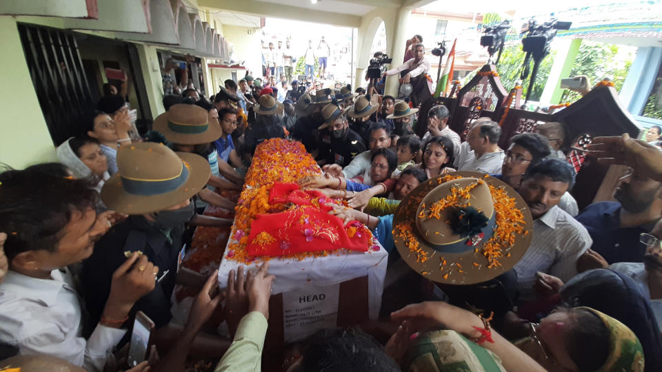 Family members stretch their arms out to touch the coffin containing the remains of Chandra Shekhar, an Indian army soldier who went missing 38 years ago, in Haldwani, India, Wednesday, Aug. 17, 2022. The soldier and 17 other colleagues were occupying a ridge on Siachen Glacier, high in the Karakoram range in disputed Kashmir's Ladakh region, in May 1984 when they were hit by an avalanche, officials said. (AP Photo)