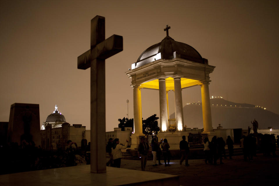 In this Dec. 6, 2012 photo, people take a nighttime guided tour through the Presbitero Matias Maestro cemetery in Lima, Peru. There are no more burials anymore, unless a family owns a mausoleum. (AP Photo/Rodrigo Abd)