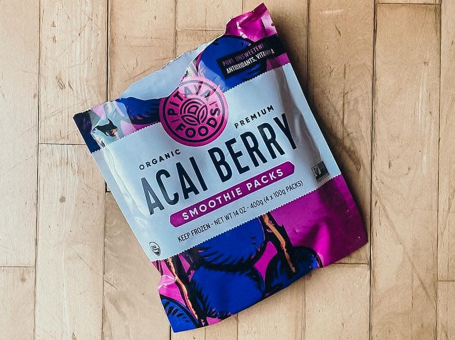 package of pitaya foods organic premium frozen acai berry smoothie packs on a wooden surface