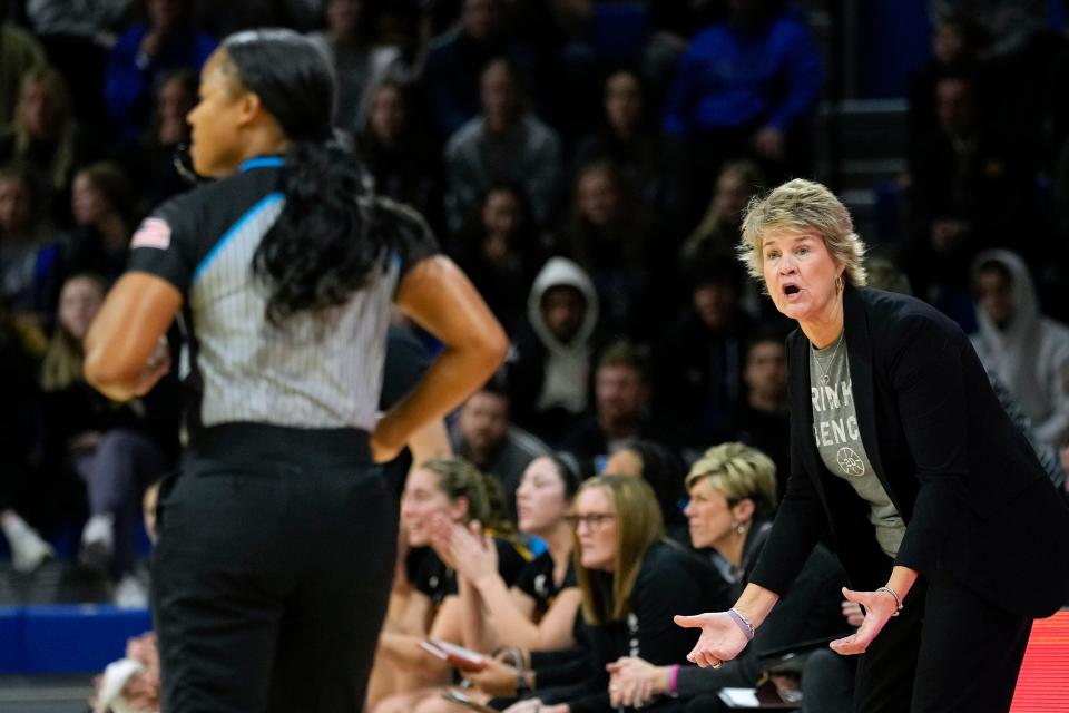 Iowa women's basketball head coach Lisa Bluder wearing a T-shirt the reads 'Brink's Bench' in support of Lisa Brinkmeyer during a game against Drake in 2022