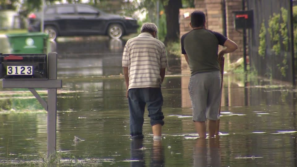 People wade through floodwaters in Houston, Texas, on May 9, 2024. - KHOU