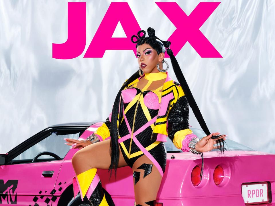 Jax poses for her season 15 "RuPaul's Drag Race" headshot in a yellow, pink and black bodysuit with matching heeled boots.