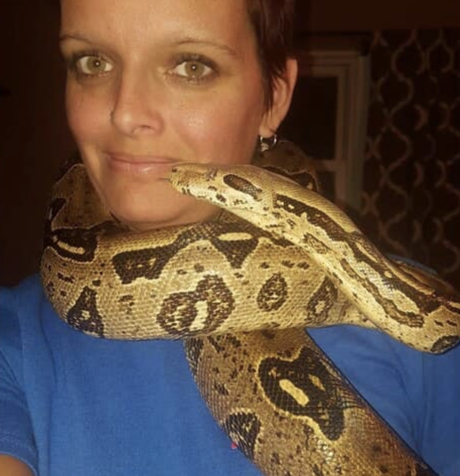 Picture of Laura Hurst, with a snake wrapped around her. The 36-year-old from Indiana was found strangled to death by a snake.