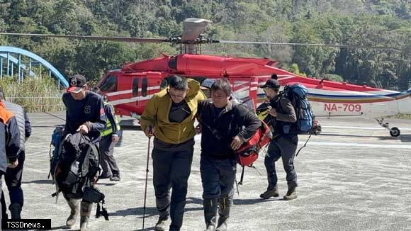 空警直升機搭載二名迷路受傷山友，降落同富停機坪。(南投縣府消防局提供)