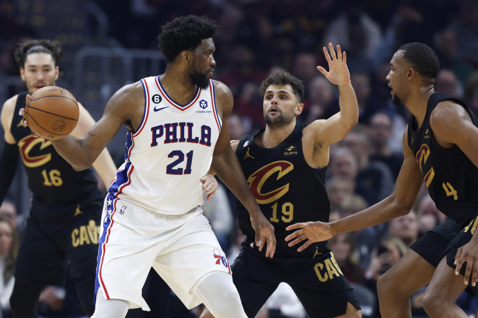 Philadelphia 76ers center Joel Embiid (21) plays against Cleveland Cavaliers guard Raul Neto (19) and forward Evan Mobley (4) during the first half of an NBA basketball game, Wednesday, March 15, 2023, in Cleveland. (AP Photo/Ron Schwane)