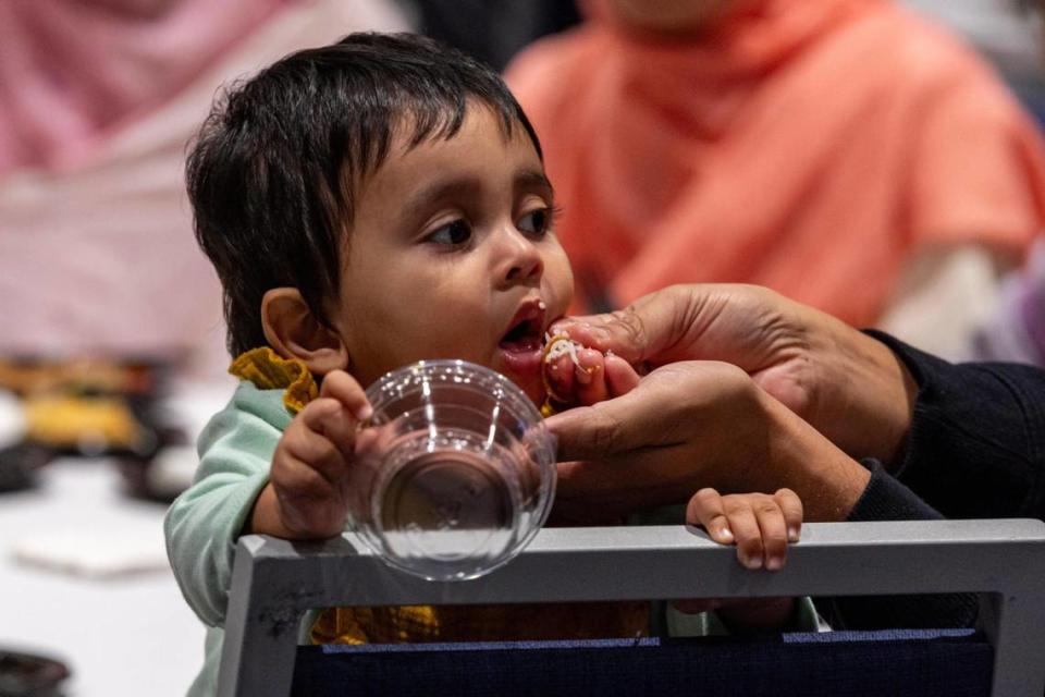Maureen, de 1 año, es alimentada por su padre Agnan, de 35, durante la cena anual interreligiosa Iftar en observancia del Ramadán organizada por el Centro de Estudios del Mundo Musulmán en el Salón de Baile del Centro Graham de la Universidad Internacional de la Florida, en Miami, Florida, el martes 19 de marzo de 2024.