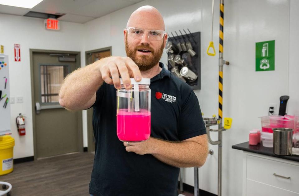 Michael White, director of research and development at Fortress Fire Retardant Systems, holds a jar of fire retardant made with magnesium chloride earlier this month. The Rocklin company has won a contract to supply the U.S. Forest Service with their retardant.