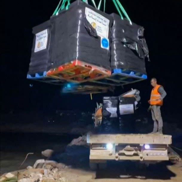 WCK workers unload food aid on to the makeshift jetty they constructed on the beach