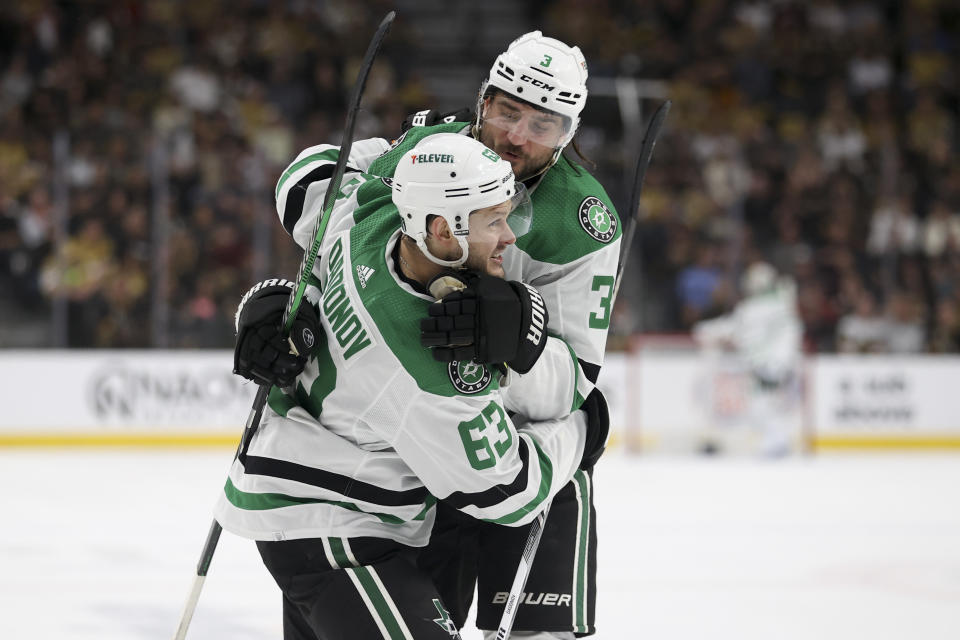 Dallas Stars right wing Evgenii Dadonov (63) and defenseman Chris Tanev (3) celebrate after Dadonov's goal during the first period against the Vegas Golden Knights in Game 4 of an NHL hockey Stanley Cup first-round playoff series Monday, April 29, 2024, in Las Vegas. (AP Photo/Ian Maule)