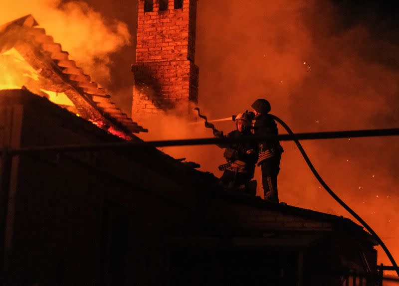 Bomberos ucranianos apagan el fuego en una casa residencial después de un ataque militar ruso. en Bajmut