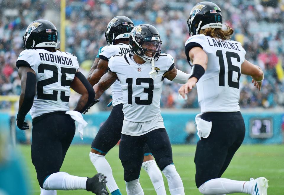 Jacksonville Jaguars wide receiver Christian Kirk (13) is all smiles as he runs off the field with teammates running back James Robinson (25) and quarterback Trevor Lawrence (16) after Kirk's first quarter touchdown. The Jaguars went into the first half with a 17 to 0 lead over the Colts. The Jacksonville Jaguars hosted the Indianapolis Colts at TIAA Bank field in Jacksonville, FL Sunday, September 18, 2022. [Bob Self/Florida Times-Union]