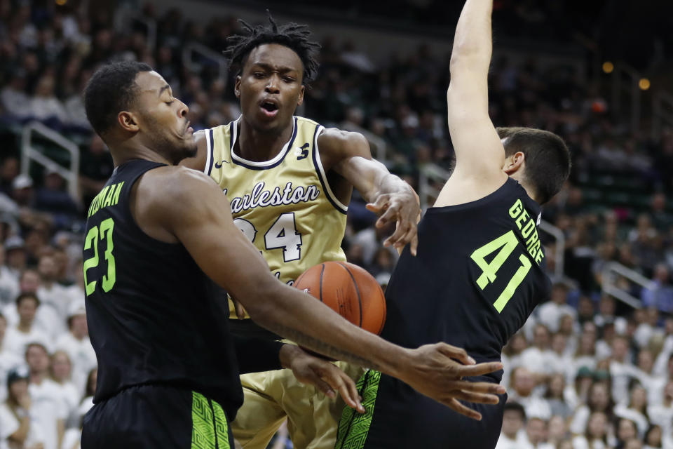 Charleston Southern guard Phlandrous Fleming Jr. (24) is defended by Michigan State forward Xavier Tillman (23) and guard Conner George (41) during the first half of an NCAA college basketball game, Monday, Nov. 18, 2019, in East Lansing, Mich. (AP Photo/Carlos Osorio)