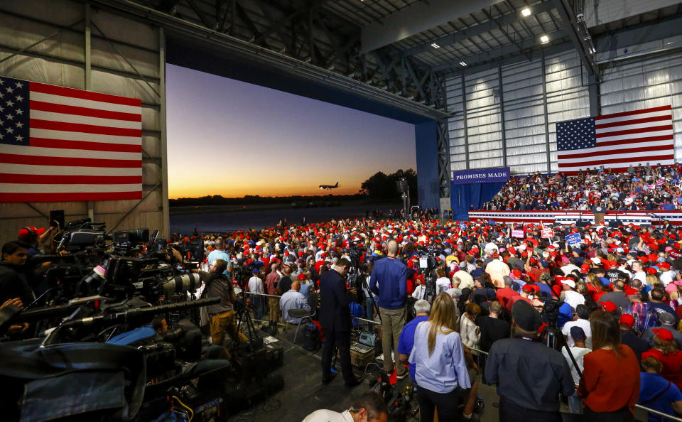Supporters watch as Air Force One lands outside the hanger where they wait for President Donald Trump to speak at a rally, Saturday, Nov. 3, 2018, in Pensacola, Fla. (AP Photo/Butch Dill)