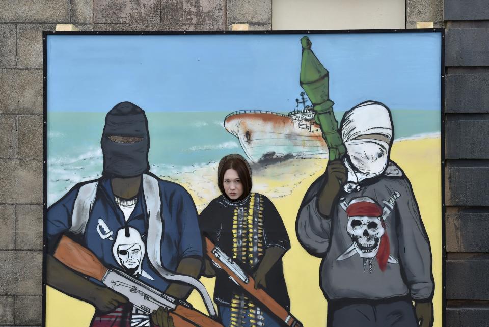 A visitor looks through a board at 'Dismaland', a theme park-styled art installation by British artist Banksy, at Weston-Super-Mare in southwest England