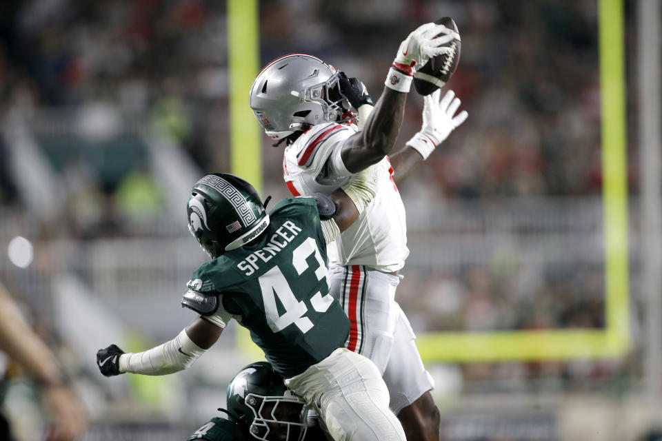 Ohio State wide receiver Jeremiah Smith, right, catches a pass for a first down against Michigan State defensive end Malik Spencer (43) during the first half of an NCAA college football game, Saturday, Sept. 28, 2024, in East Lansing, Michigan (AP Photo/Al Goldis)