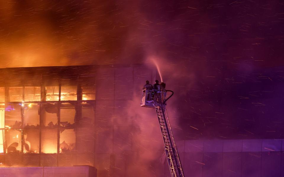 Rescuers work to extinguish fire at the burning Crocus City Hall concert venue