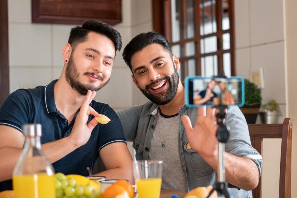 two men waving at a camera