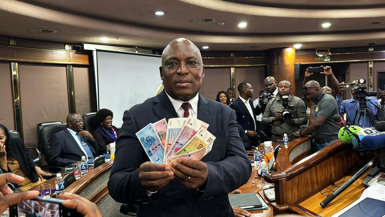 John Mushayavanhu, Governor of the Reserve Bank of Zimbabwe, presents the new national currency Zimbabwe Gold, or ZiG.