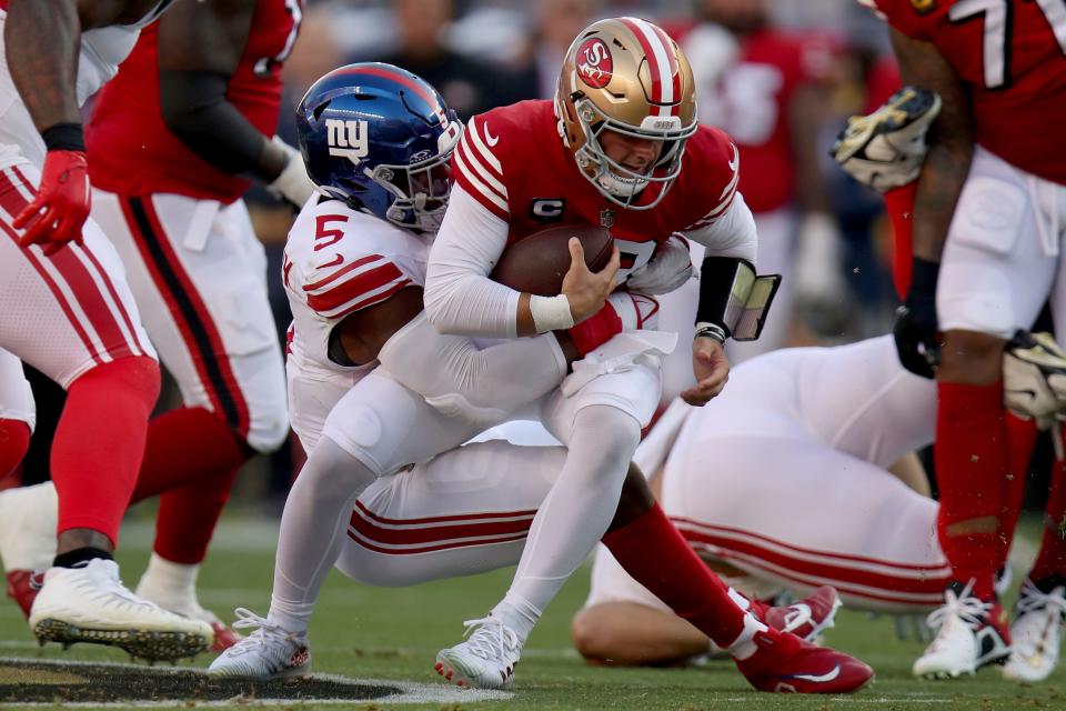 San Francisco 49ers quarterback Brock Purdy (13) is brought down by New York Giants linebacker Kayvon Thibodeaux (5) during an NFL football game, Thursday, Sept. 21, 2023, in Santa Clara, Calif. (AP Photo/Scot Tucker)