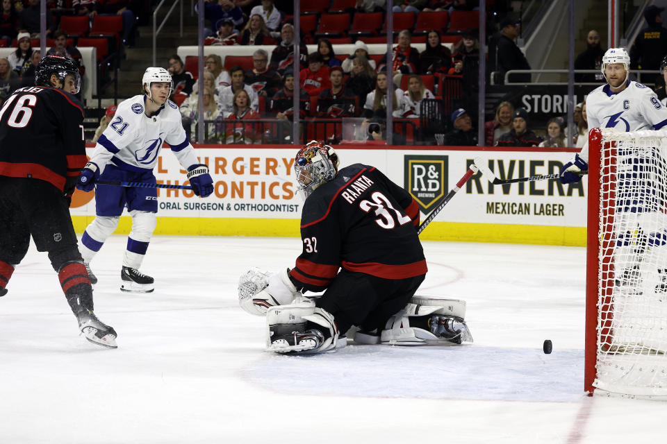 Tampa Bay Lightning's Brayden Point (21) shoots the puck past Carolina Hurricanes goaltender Antti Raanta (32) for a hat trick during the third period of an NHL hockey game in Raleigh, N.C., Friday, Nov. 24, 2023. (AP Photo/Karl B DeBlaker)