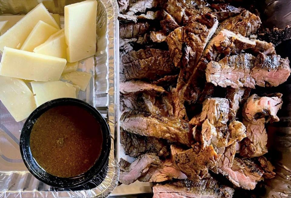 Sliced grilled skirt steak, aged white cheddar cheese and steak sauce ready to be assembled into steak sandwiches from To the Table Catering.