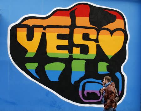 Men walk past a Yes vote campaign graffiti in central Dublin as Ireland holds a referendum on gay marriage, May 22, 2015. REUTERS/Darren Staples